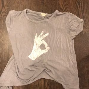 A girl’s shirt that has a OK sign in the front